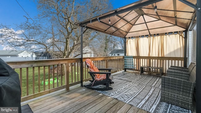 wooden terrace featuring a yard and a gazebo