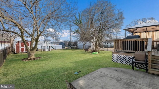 view of yard with a gazebo, a shed, a playground, and a trampoline