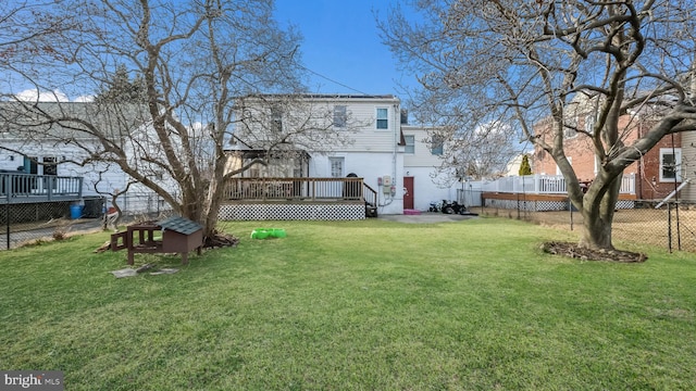 back of property featuring a wooden deck and a lawn