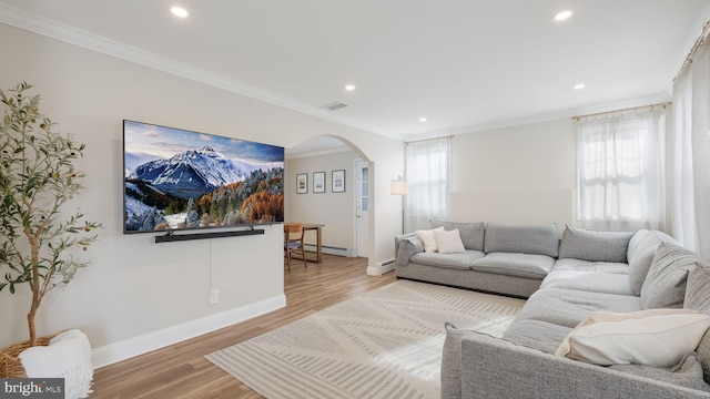 living room with crown molding, a baseboard radiator, and light wood-type flooring