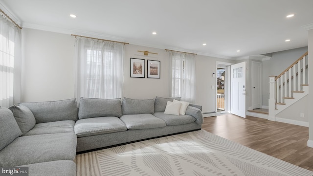 living room with hardwood / wood-style floors, crown molding, and a baseboard heating unit