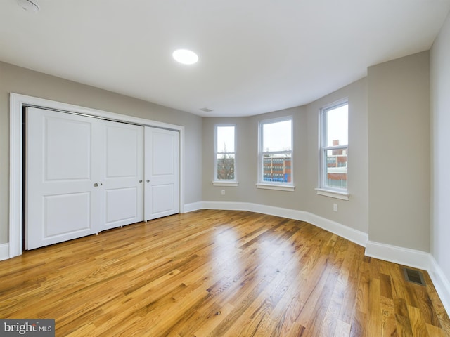 unfurnished bedroom with a closet and light wood-type flooring