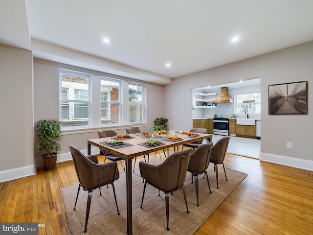 dining space with sink and light hardwood / wood-style flooring