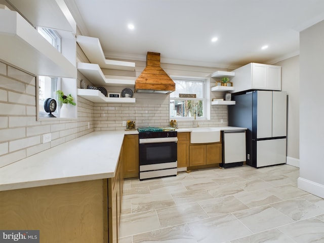 kitchen featuring sink, custom exhaust hood, refrigerator, electric range, and dishwashing machine