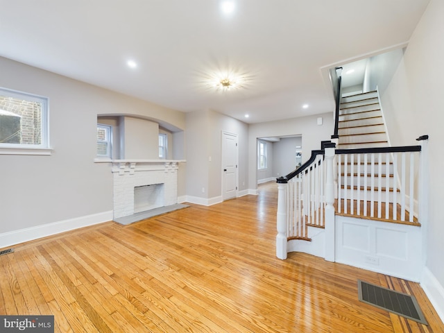 staircase featuring wood-type flooring and a fireplace