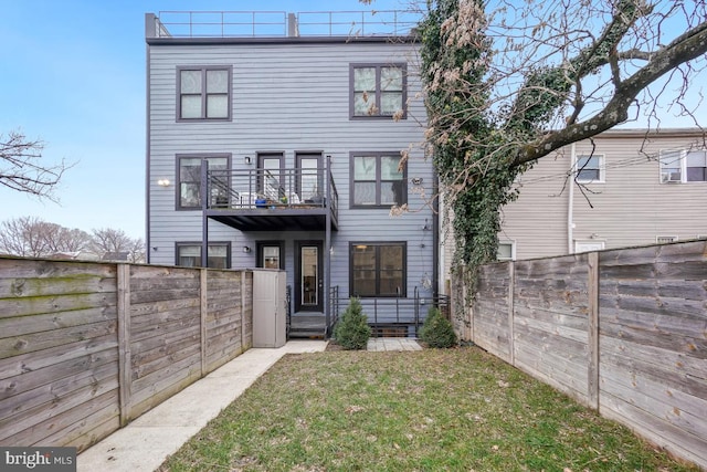 view of front facade featuring a front lawn and a balcony