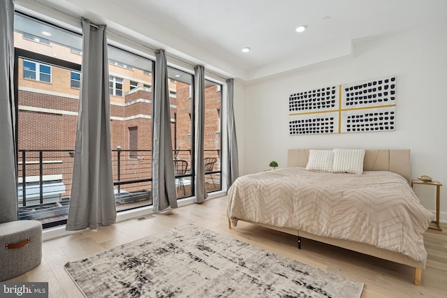 bedroom with access to exterior and light hardwood / wood-style floors