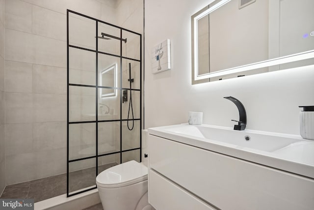 bathroom featuring vanity, toilet, and tiled shower