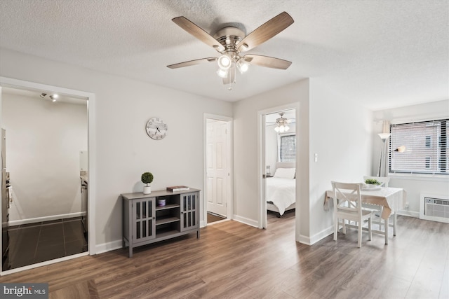 interior space featuring dark wood-type flooring, a wall mounted AC, and a textured ceiling