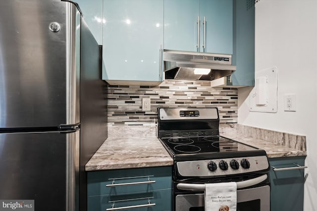 kitchen with blue cabinetry, stainless steel appliances, light stone counters, and backsplash