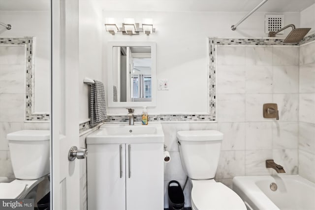 full bathroom featuring vanity, toilet, bathing tub / shower combination, and tile walls