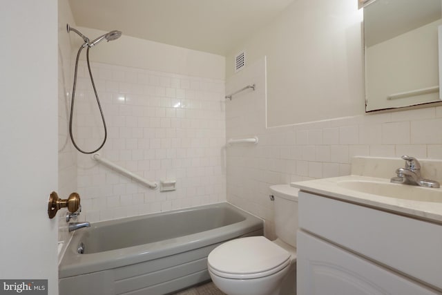 full bathroom featuring vanity, toilet, tiled shower / bath combo, and tile walls