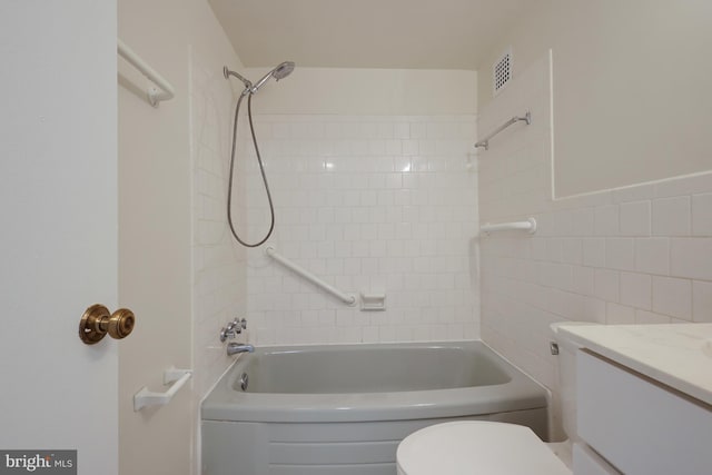 full bathroom with tiled shower / bath combo, vanity, tile walls, and toilet