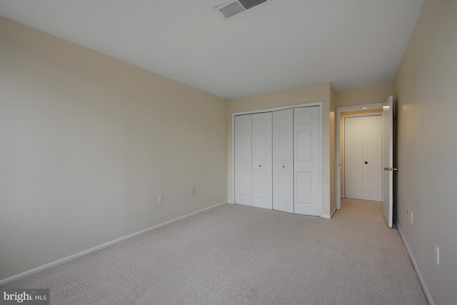 unfurnished bedroom featuring a closet and light carpet