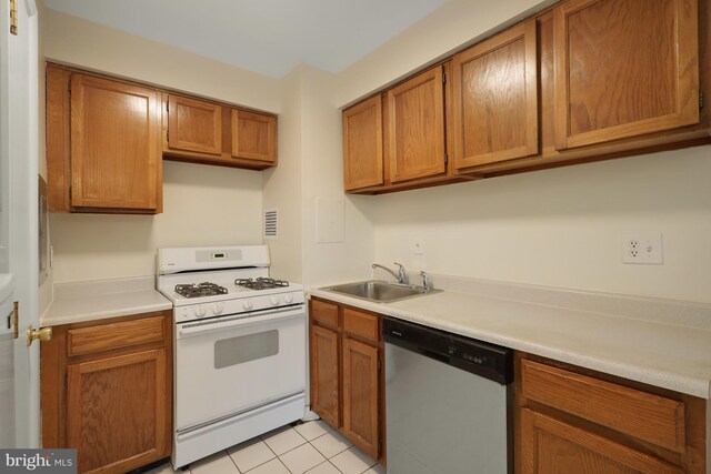 kitchen with stainless steel dishwasher, white gas range, sink, and light tile patterned floors