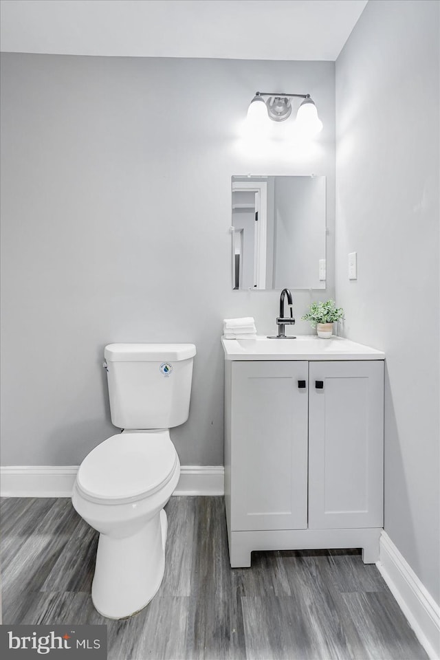 bathroom with vanity, hardwood / wood-style floors, and toilet