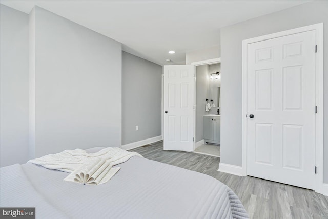 bedroom with hardwood / wood-style flooring and ensuite bathroom