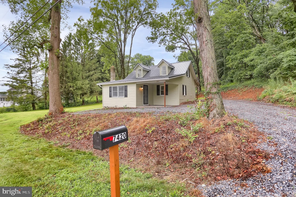 view of front of property featuring covered porch and a front lawn