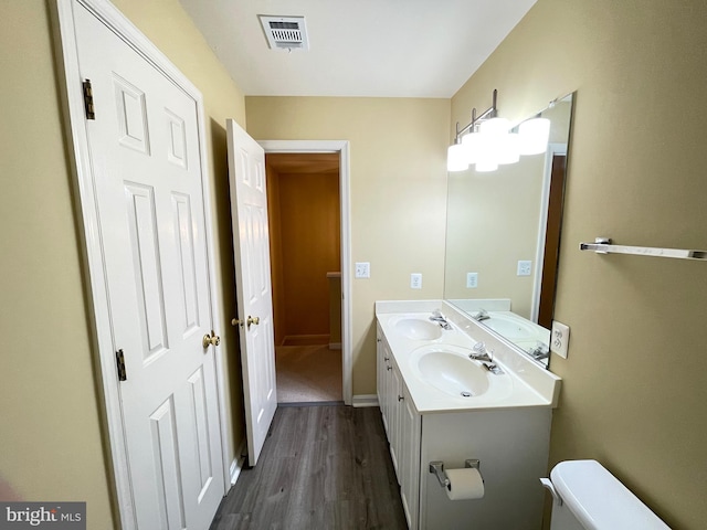 bathroom with vanity, wood-type flooring, and toilet