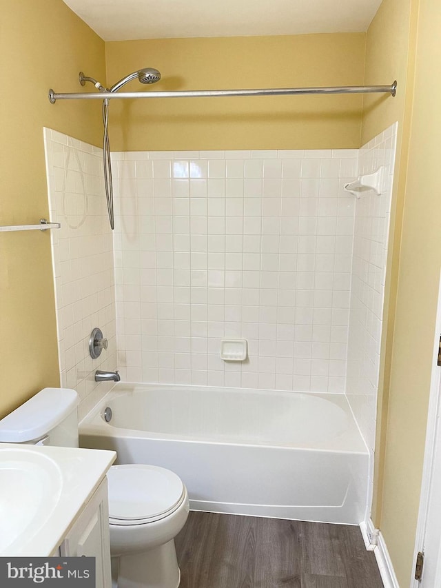 full bathroom with wood-type flooring, toilet, tiled shower / bath combo, and vanity