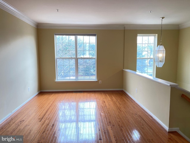 unfurnished room featuring a notable chandelier, crown molding, and light hardwood / wood-style flooring