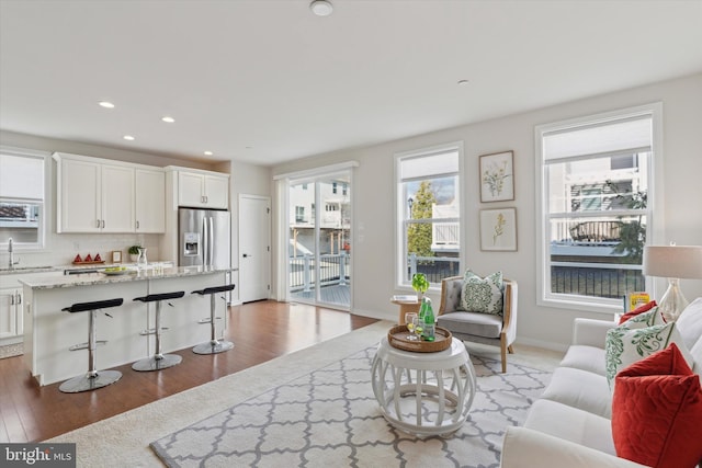 living room featuring sink and light hardwood / wood-style floors