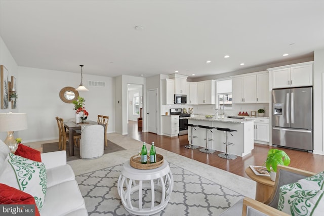 living room featuring hardwood / wood-style flooring and sink