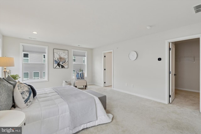 carpeted bedroom with a walk in closet