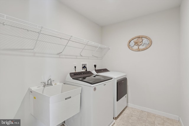 clothes washing area with sink and independent washer and dryer