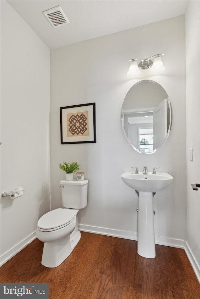 bathroom featuring hardwood / wood-style flooring and toilet