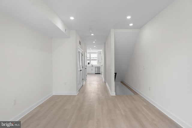 hallway with sink and light wood-type flooring