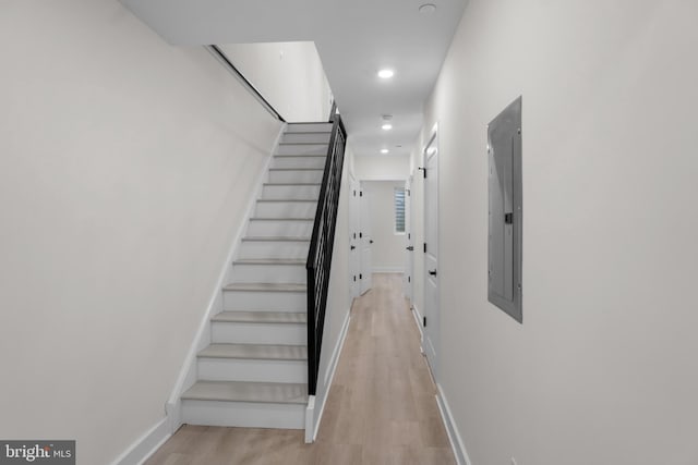 staircase with hardwood / wood-style flooring and electric panel