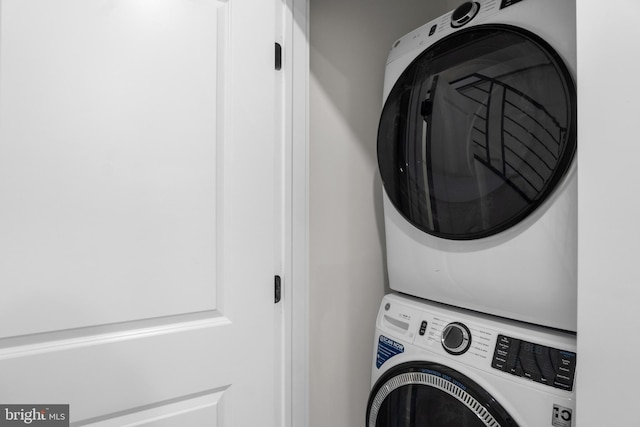 clothes washing area featuring stacked washing maching and dryer