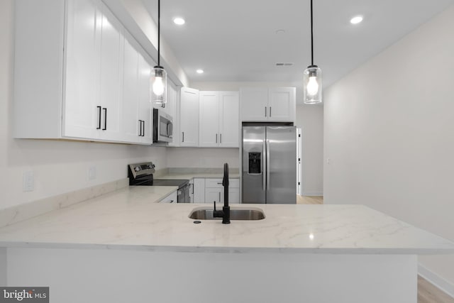 kitchen with pendant lighting, sink, white cabinets, kitchen peninsula, and stainless steel appliances