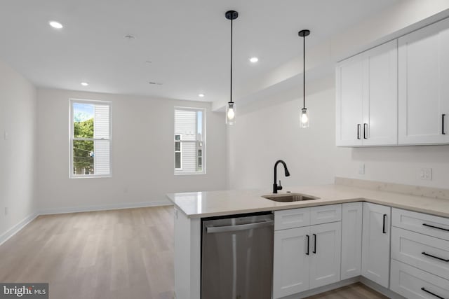 kitchen with stainless steel dishwasher, sink, hanging light fixtures, and white cabinets