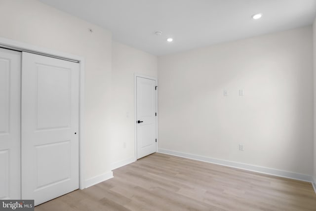 unfurnished bedroom with light hardwood / wood-style floors and a closet