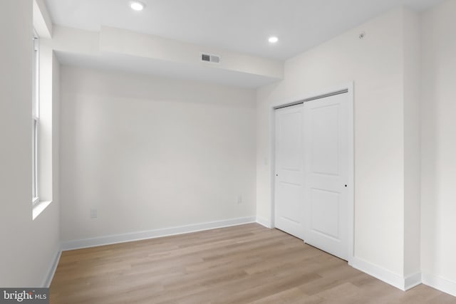 unfurnished bedroom featuring a closet and light hardwood / wood-style flooring