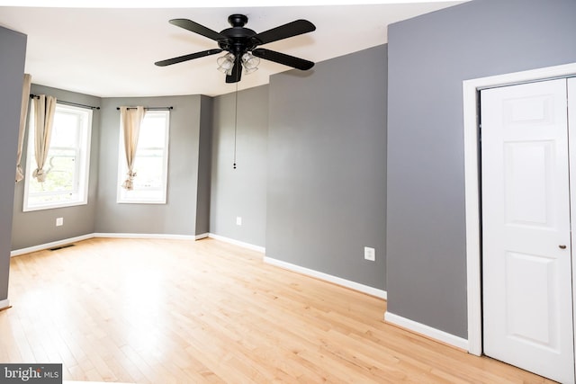 unfurnished room with ceiling fan and light wood-type flooring