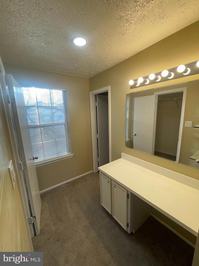 bathroom featuring a textured ceiling and baseboards