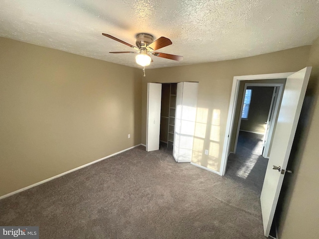 unfurnished bedroom with carpet floors, a closet, a ceiling fan, a textured ceiling, and baseboards