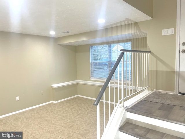 staircase with visible vents and baseboards