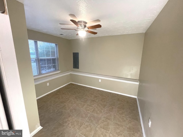 empty room featuring a ceiling fan, a textured ceiling, and baseboards