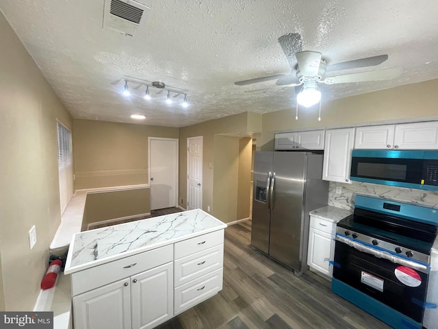 kitchen featuring a textured ceiling, stainless steel appliances, dark wood-style flooring, visible vents, and white cabinetry