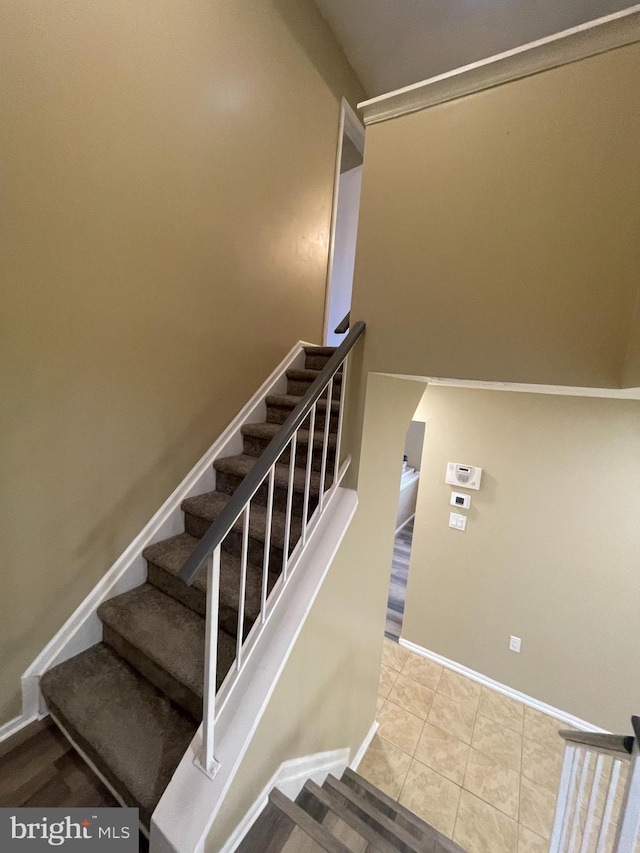 stairway with tile patterned flooring and baseboards