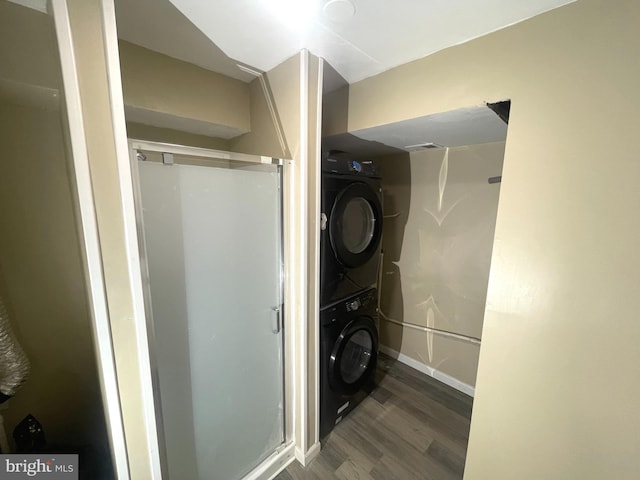 washroom with baseboards, laundry area, dark wood finished floors, and stacked washer / drying machine