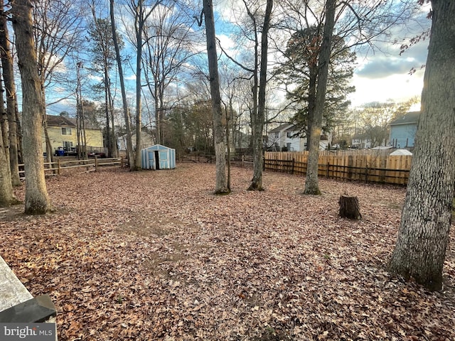 view of yard with a shed, an outdoor structure, and fence