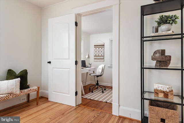 sitting room with wood-type flooring and ornamental molding