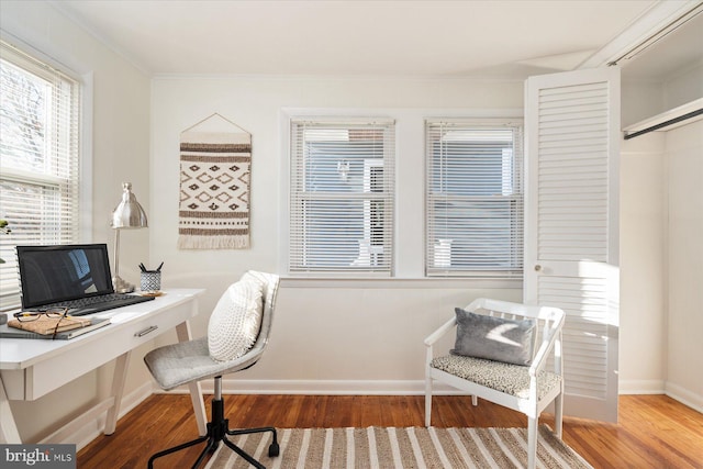 home office featuring ornamental molding, hardwood / wood-style floors, and built in desk