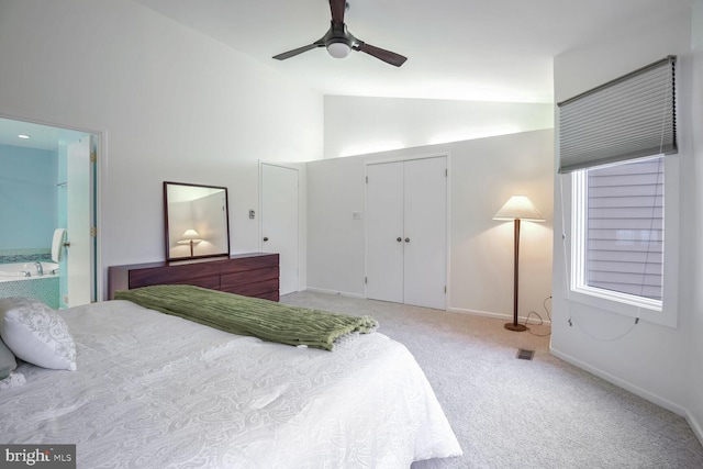 carpeted bedroom with ceiling fan, ensuite bathroom, high vaulted ceiling, and a closet