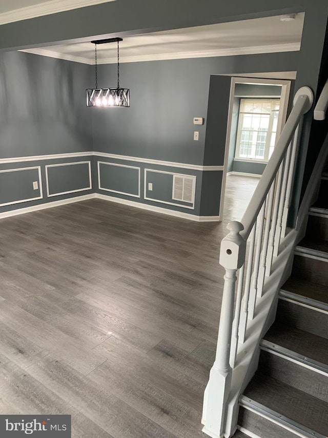 unfurnished dining area with ornamental molding and wood-type flooring